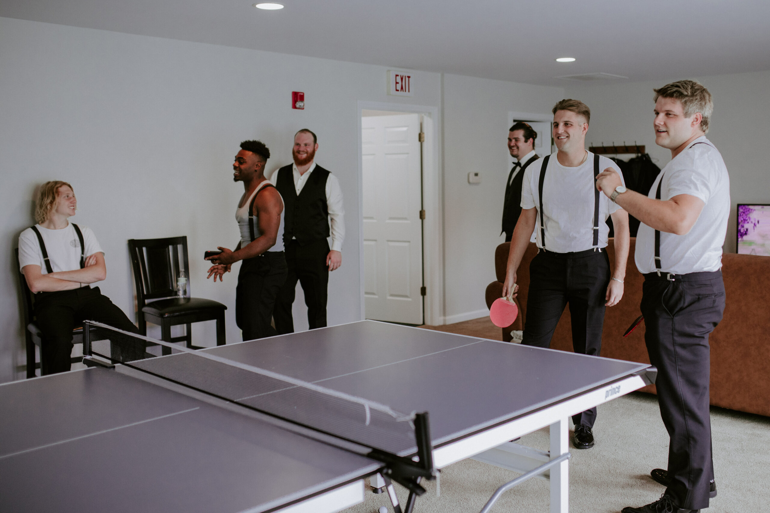 Groomsmen playing ping pong before wedding ceremony