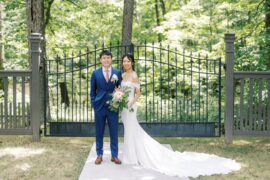 Bride and Groom stand in front of ornate gate