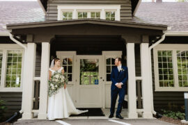 Bride and Groom standing at front door of The Bluffs at Conner Prairie